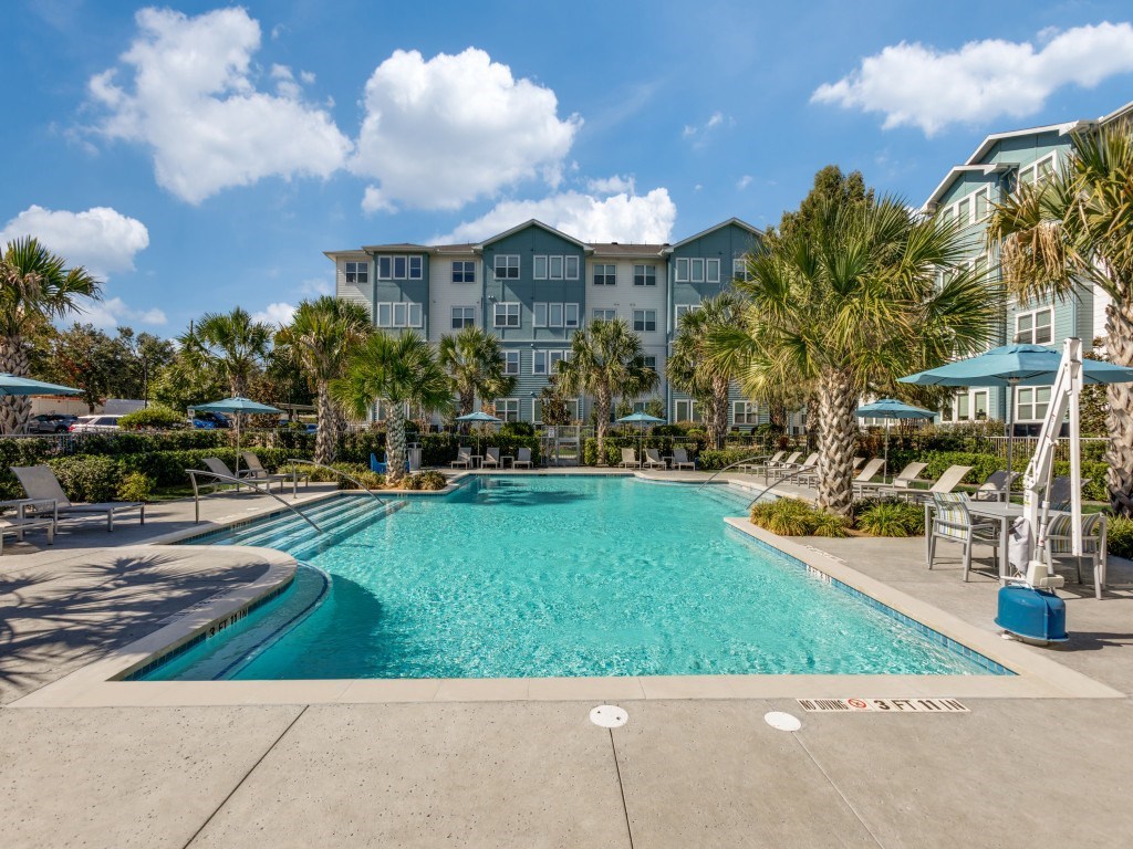 A large swimming pool in front of a resort.
