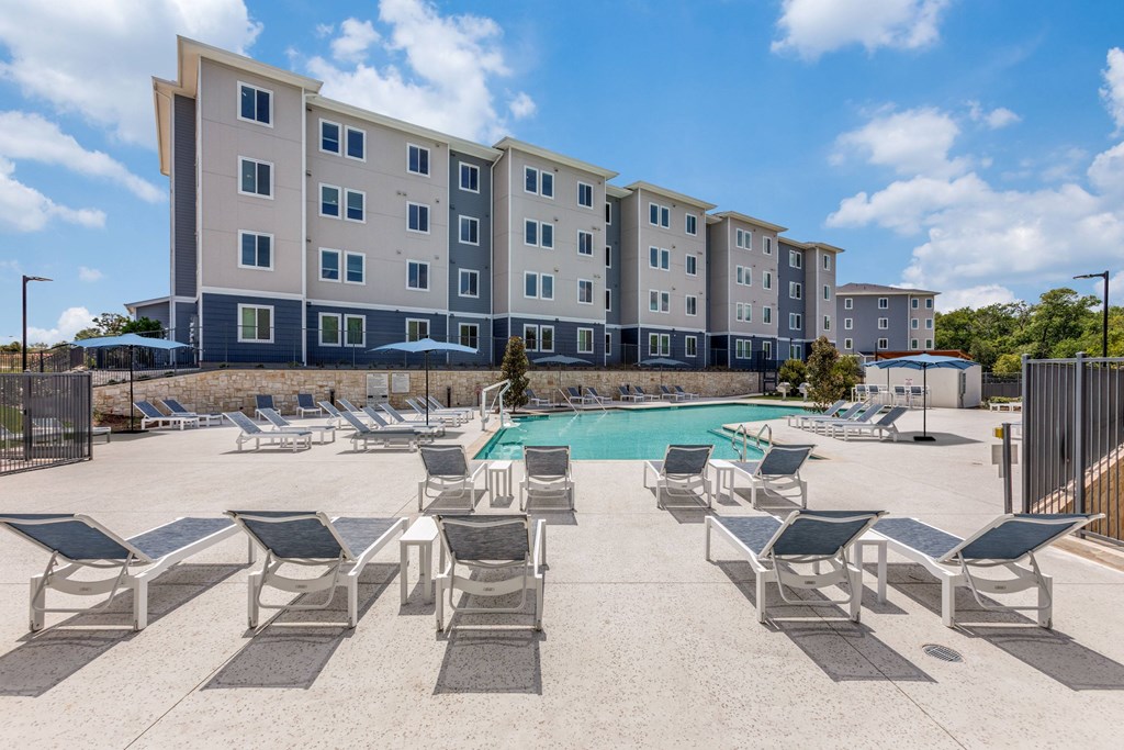 Resort style swimming pool with loungers.