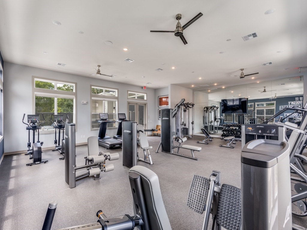 A spacious gym with a variety of equipment including treadmills, weights, and exercise machines.