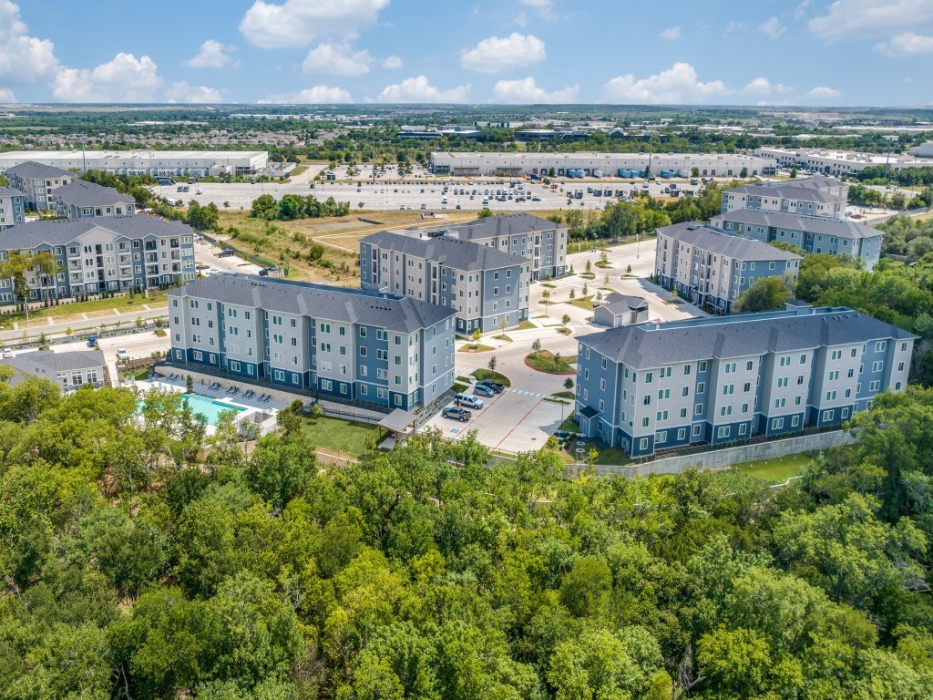 A bird's eye view of a resort with multiple buildings and a swimming pool.