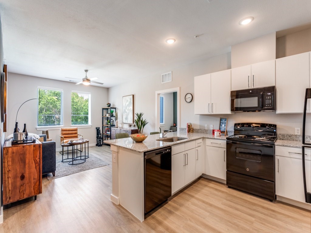 A kitchen with white cabinets and a wooden island.