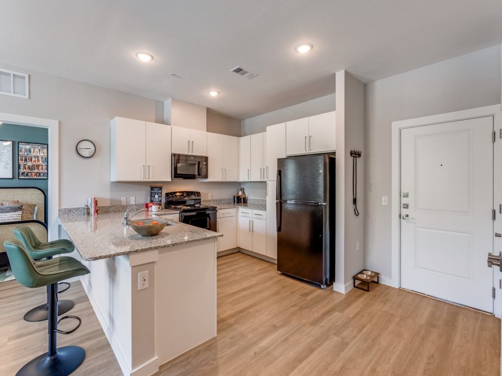 A kitchen with a refrigerator, stove, and counter.