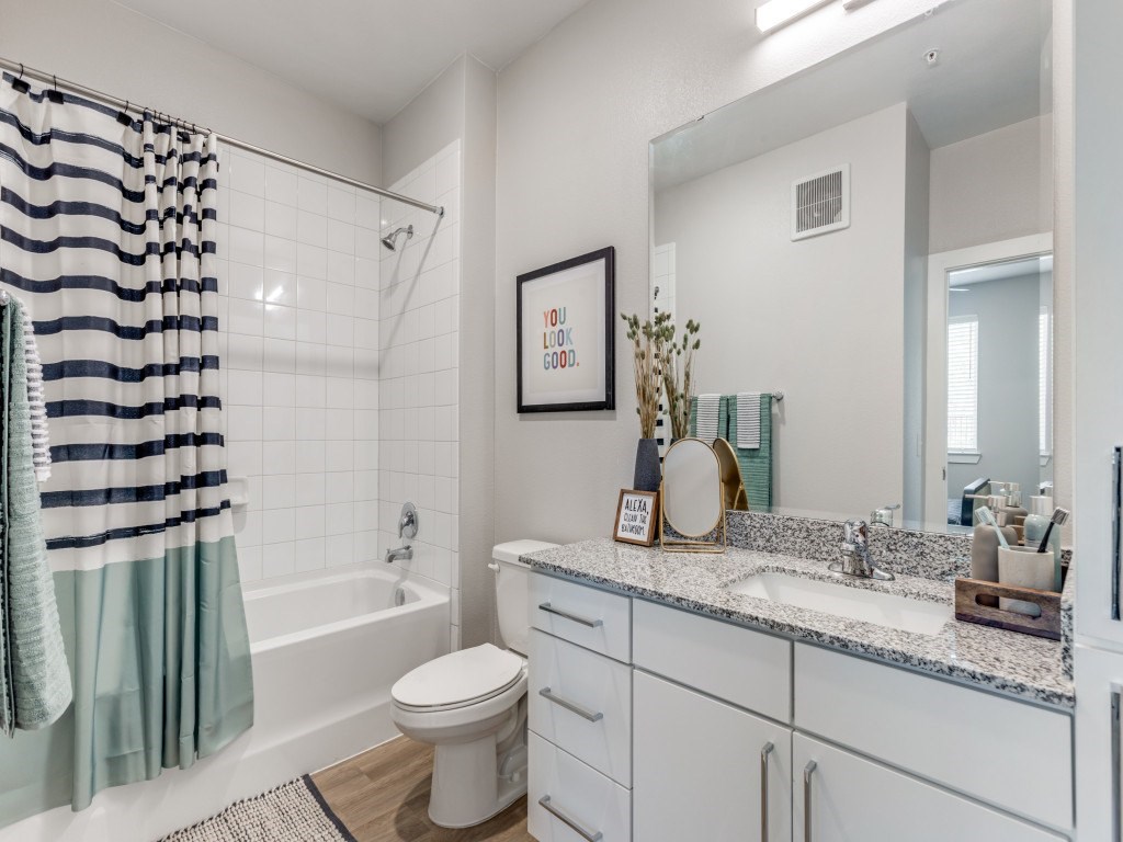 A bathroom with a striped shower curtain and a white toilet.