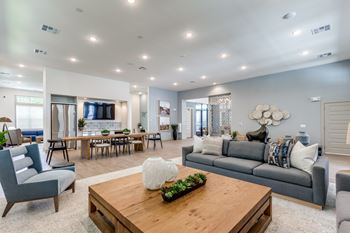 A modern living room with a grey sofa, a wooden coffee table, and a large window.