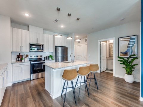 A kitchen with white cabinets and a wooden floor.
