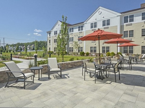 a patio with tables and umbrellas in front of a building