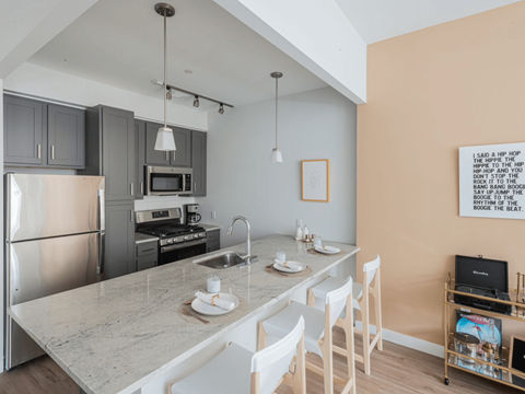 a kitchen with a marble counter top and stainless steel appliances