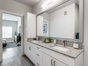 Elegant Bathrooms featuring Double-Sink Vanities, Granite Counters, and Glass Showers or Soaking Tubs at The Prescott Luxury Apartments in Austin, TX
