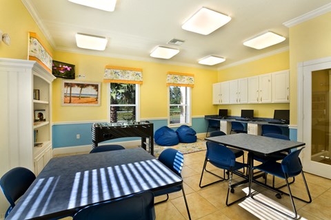 a recreation room with tables and chairs and a foosball table