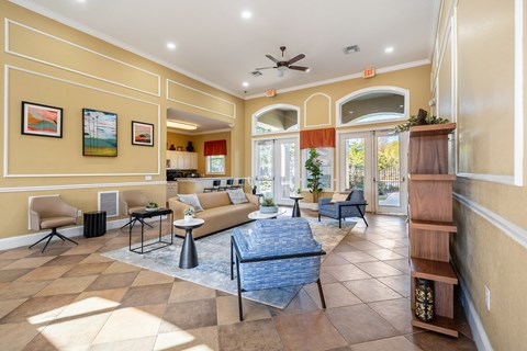 A living room with a blue rug and a ceiling fan.