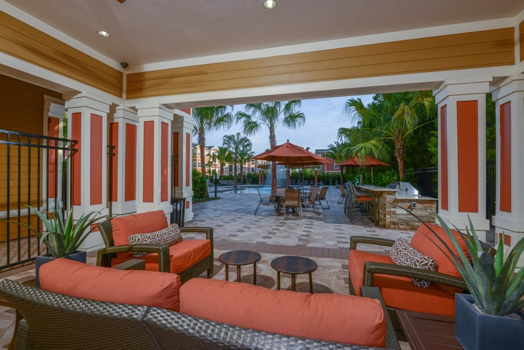 Outdoor lounge area near the grilling area by the pool at The Amalfi Clearwater Apartments