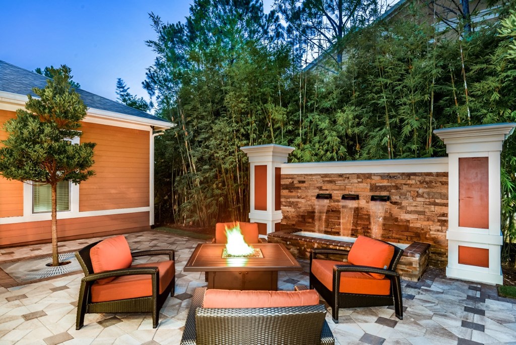 a backyard patio with a fire pit and chairs