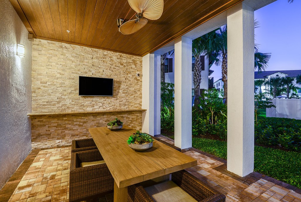 Outdoor dining area with a TV at Azura in Kendall, FL