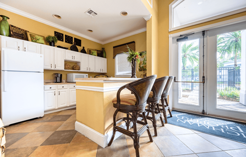 A kitchen with white cabinets and a yellow island.