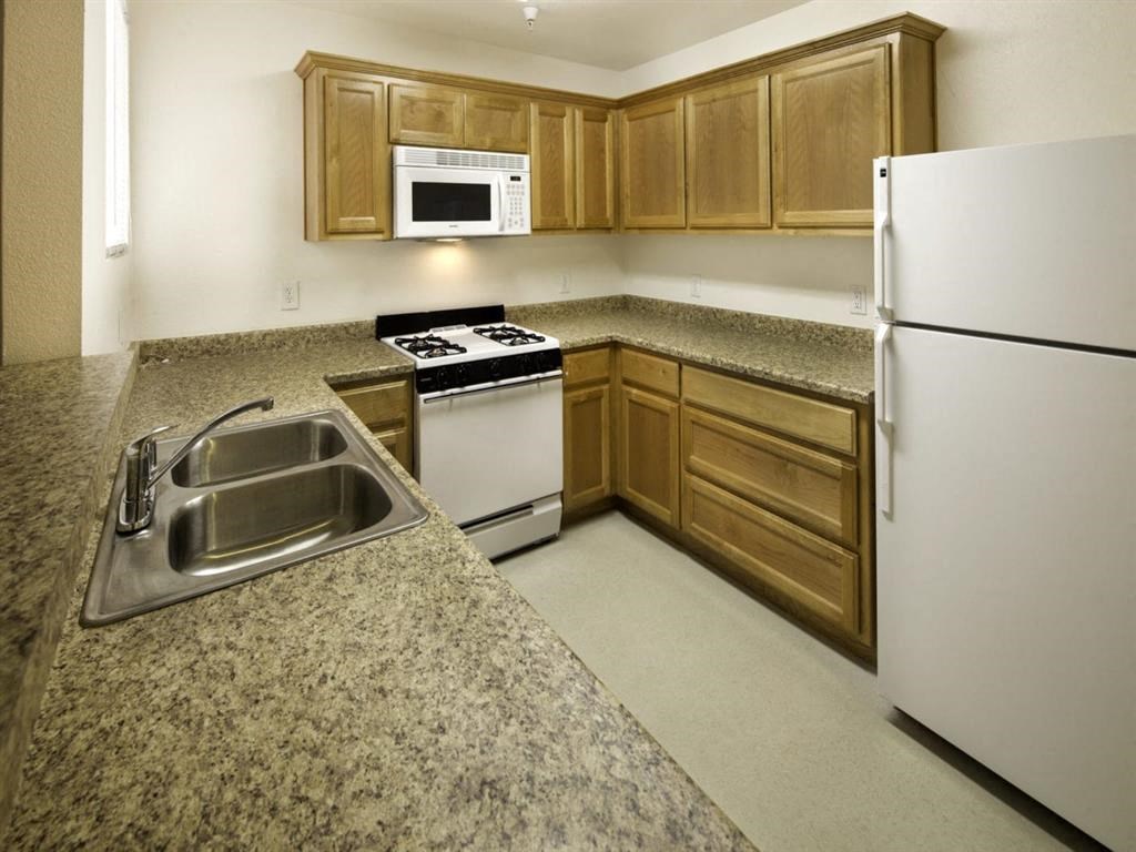 a kitchen with white appliances and granite counter tops