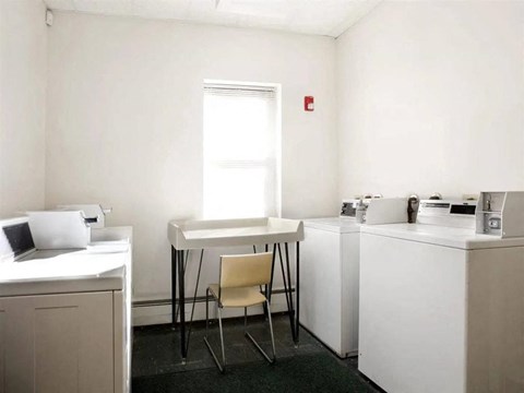 a kitchen with two washers and a table with a chair