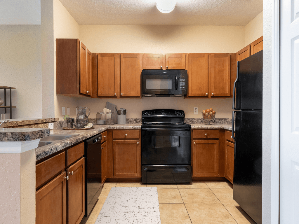 A kitchen with black appliances and wooden cabinets.