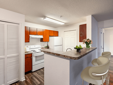 A kitchen with a white counter top and a white stove.