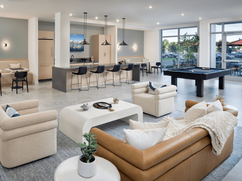 A living room with a pool table and a bar area.