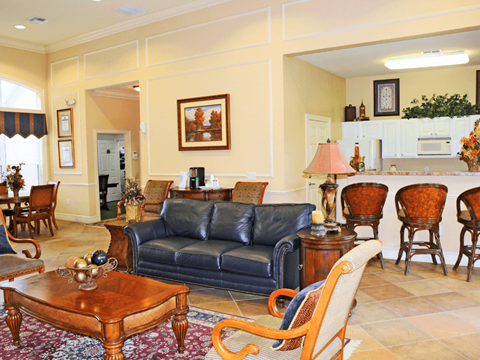 A living room with a blue couch and wooden furniture.