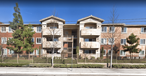 an apartment building with a fence in front of it
