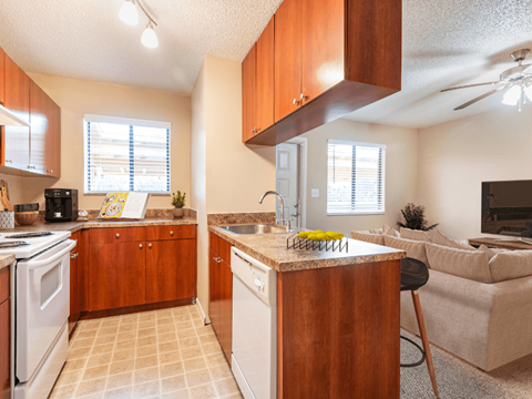 A kitchen with wooden cabinets and a white stove top oven.