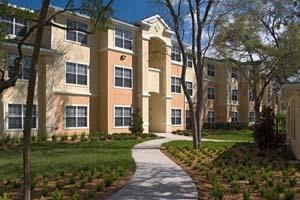 an apartment building with a sidewalk in front of it