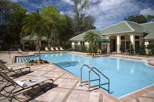a large swimming pool with chairs in front of a building