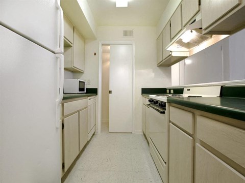 a kitchen with white cabinets and a stove and a refrigerator