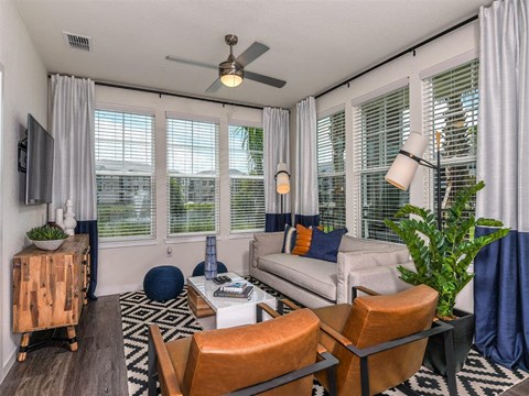 a living room with a couch and a ceiling fan
