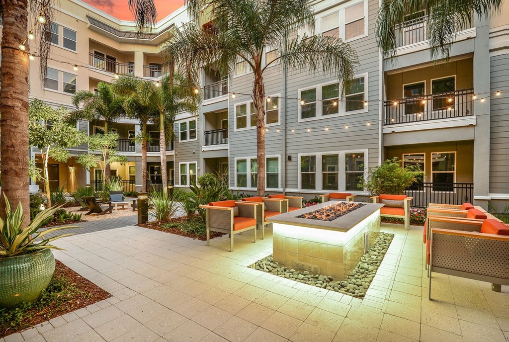 a courtyard with a fountain and chairs in front of a building at Grady Square, Florida, 33607