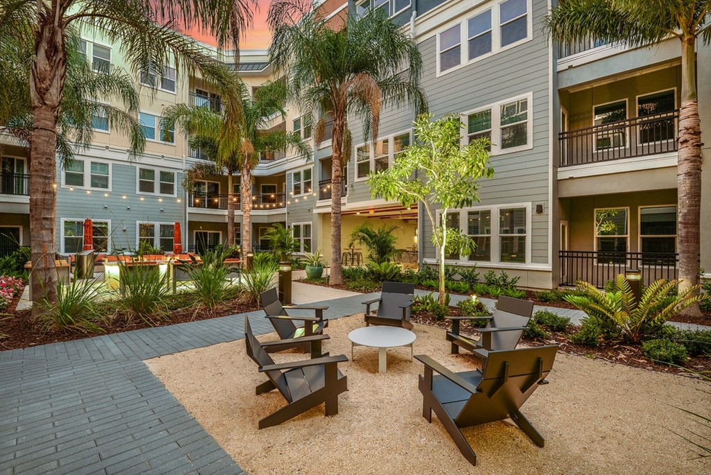 a courtyard with tables and chairs in front of an apartment building at Grady Square, Tampa, FL