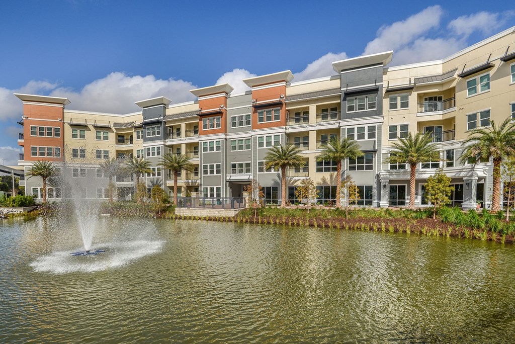 a pond with a fountain in front of an apartment building  at Grady Square, Tampa, Florida