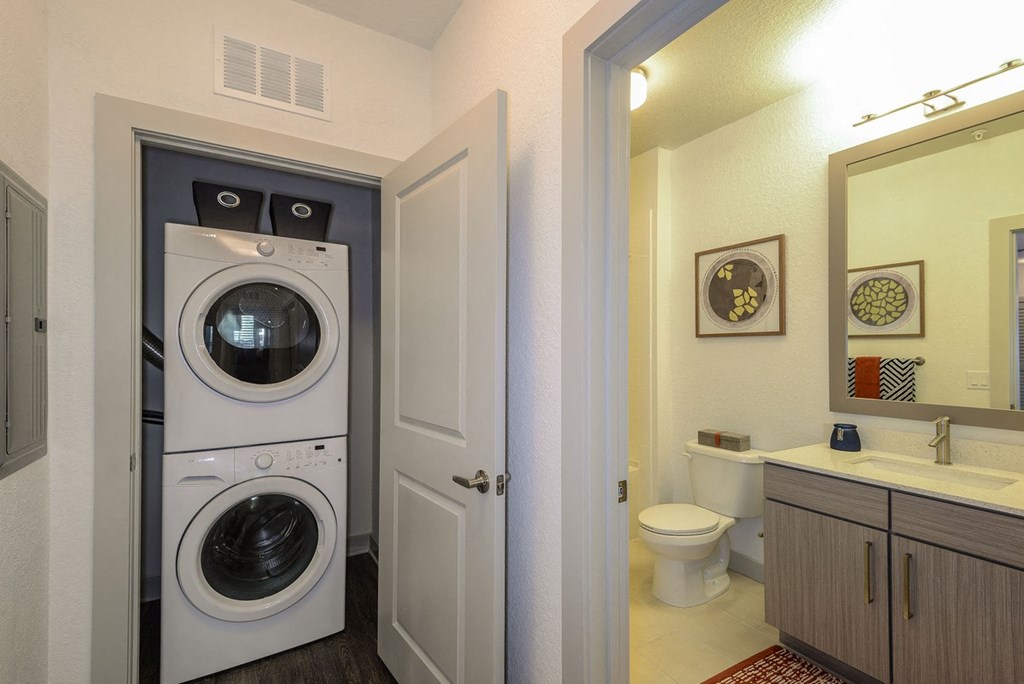 a washer and dryer in a bathroom next to a toilet at Grady Square, Florida