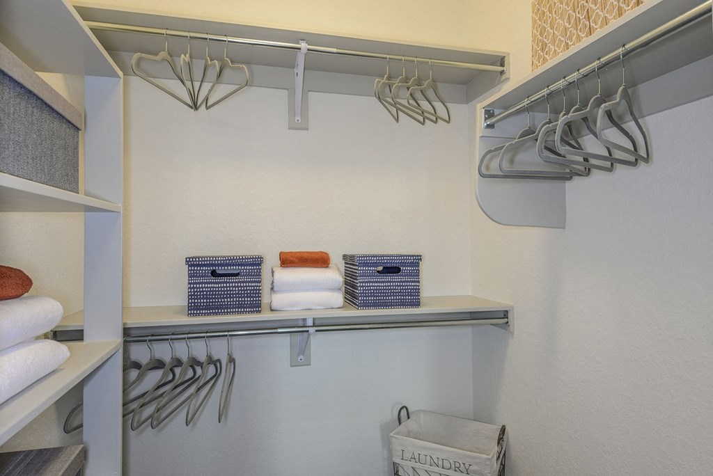 a walk in closet with folded towels and a rack of hangers at Grady Square, Tampa, Florida