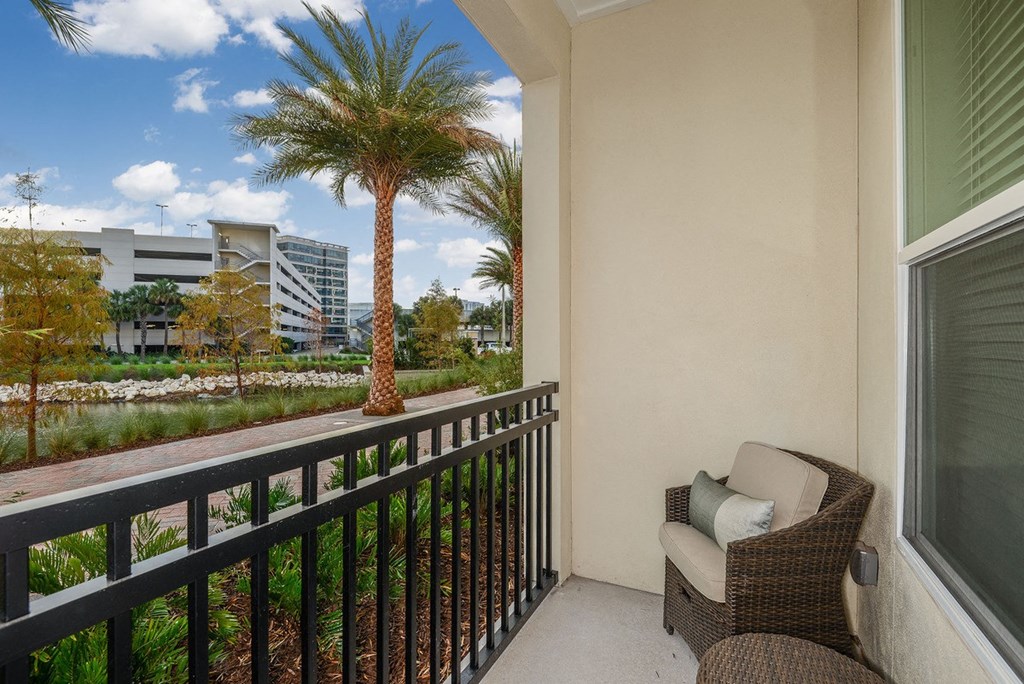 a balcony with a chair and a palm tree  at Grady Square, Tampa