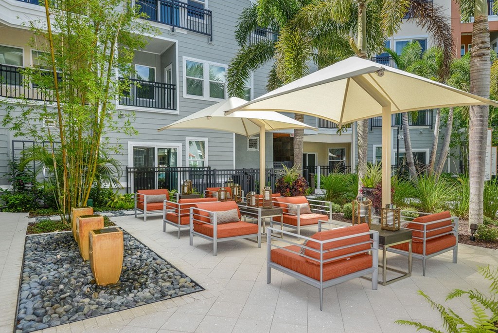a patio with chairs and umbrellas in front of a building  at Grady Square, Tampa, FL