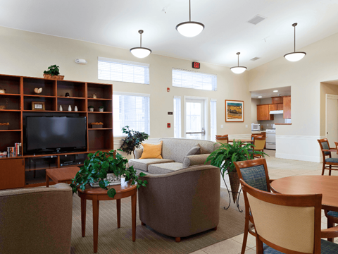 A living room with a couch, chairs, and a television.