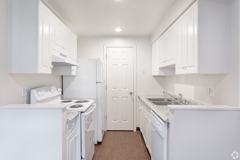 a white kitchen with white appliances and white cabinets