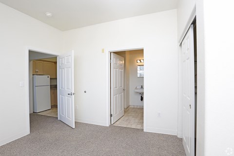 a renovated living room and kitchen with white walls and white doors