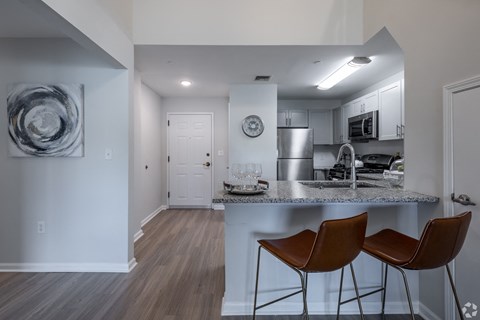 a kitchen with a marble counter top and two stools