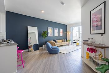 a living room with a blue accent wall and hardwood floors