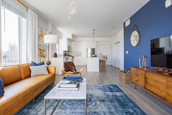 a living room with a blue accent wall and a brown leather couch