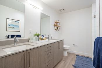 a bathroom with white walls and wood flooring