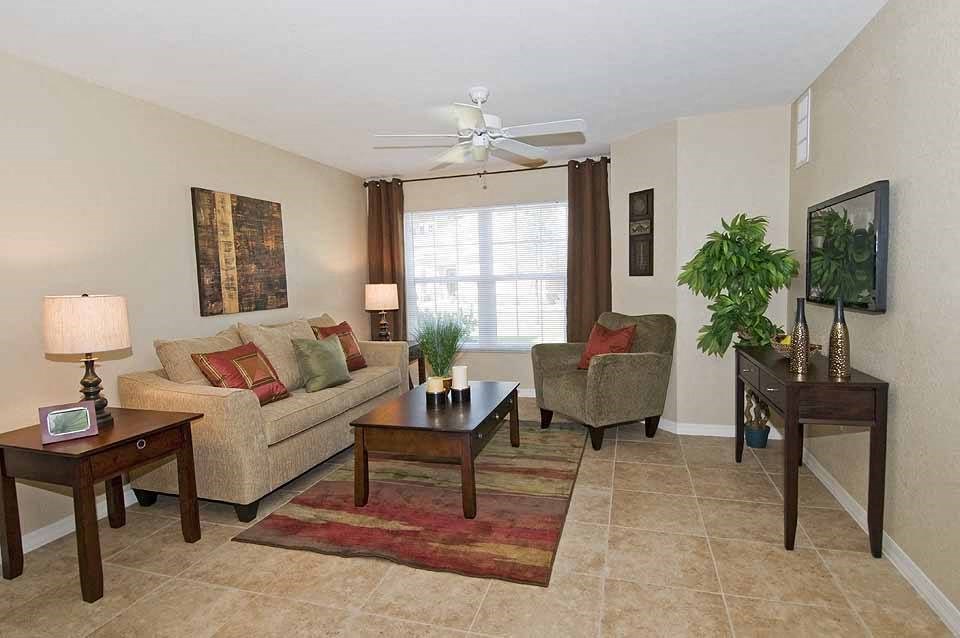 a living room filled with furniture and a ceiling fan