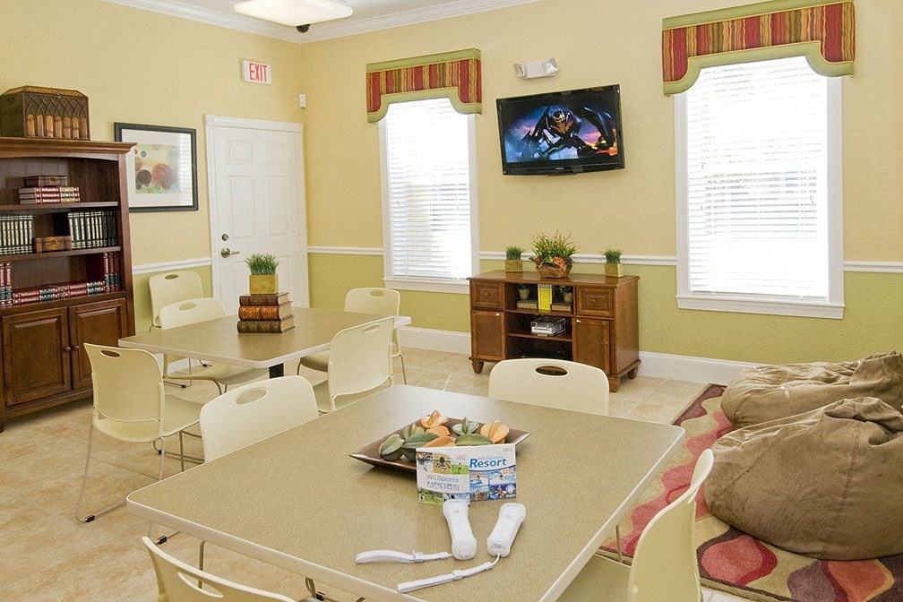 a living room with a table and chairs and a tv