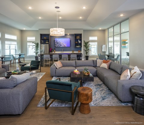 A modern living room with grey couches and a wooden coffee table.