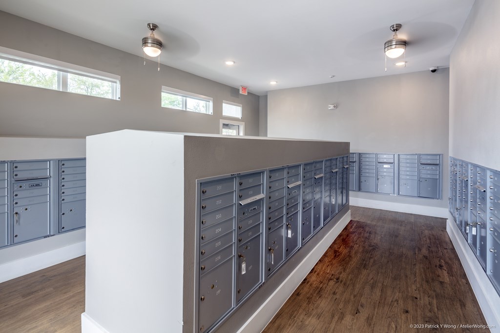 A room with a long row of mailboxes on the wall.