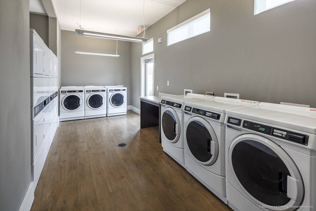 A laundry room with a row of washing machines.