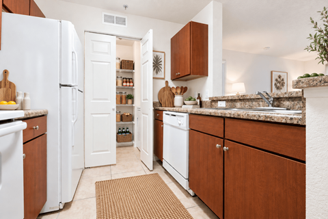 A kitchen with white appliances and wooden cabinets.